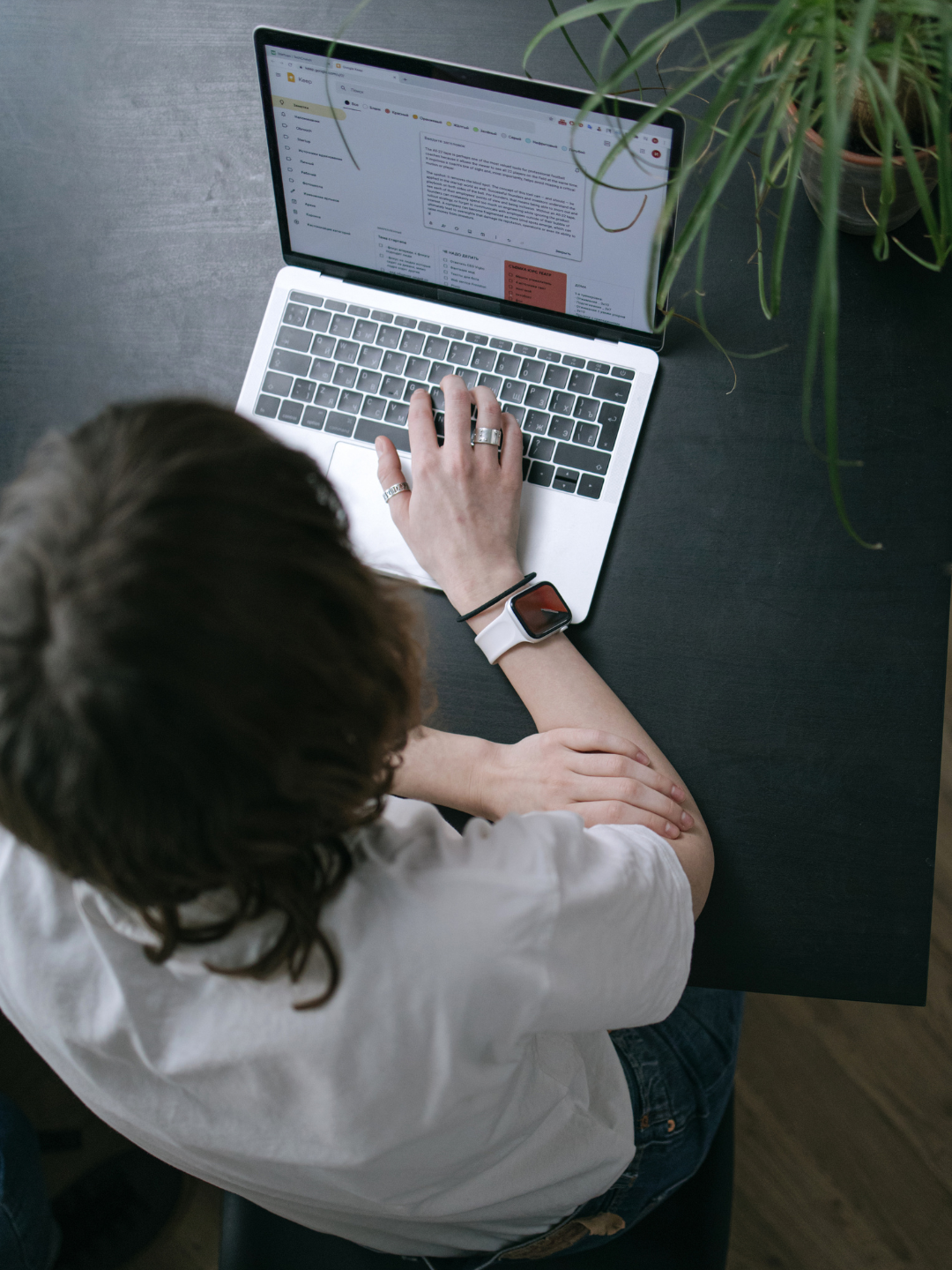 High-angle view of a professional working on a laptop at a clean, modern desk, representing the transition to a paperless office through digitisation and streamlined digital records management.